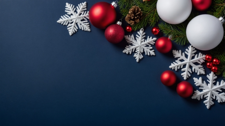 Christmas background featuring red and white ornaments on a dark blue surface, accented with snowflakes and copy space.