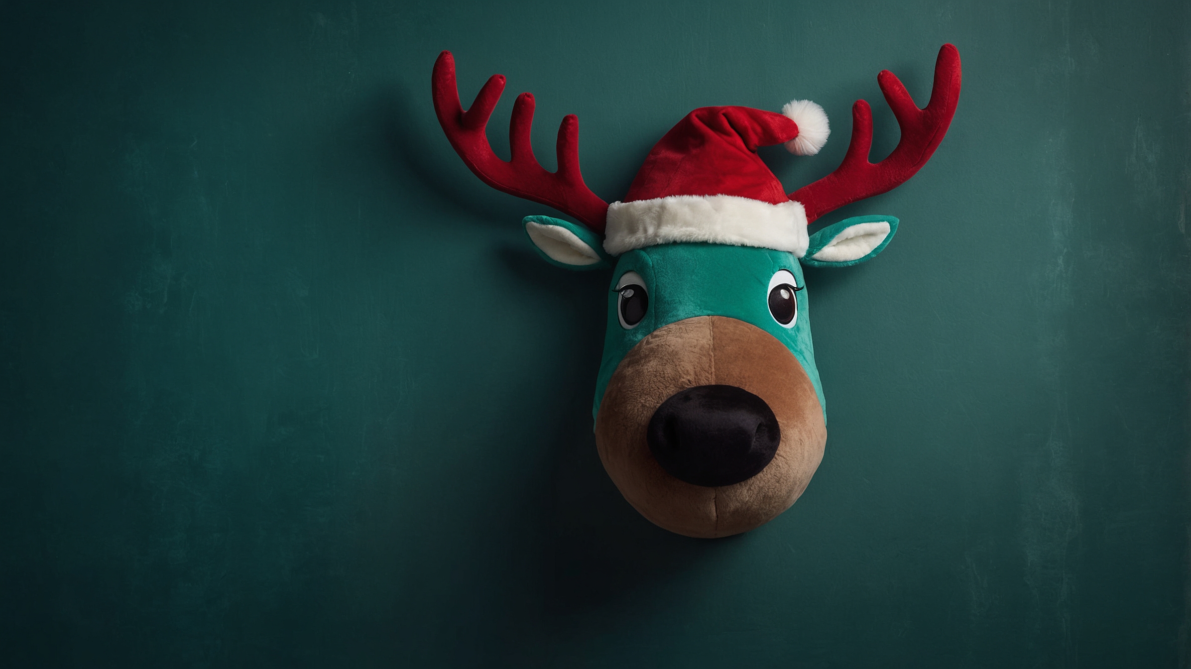 Plush Reindeer with Santa Hat Against Green Background