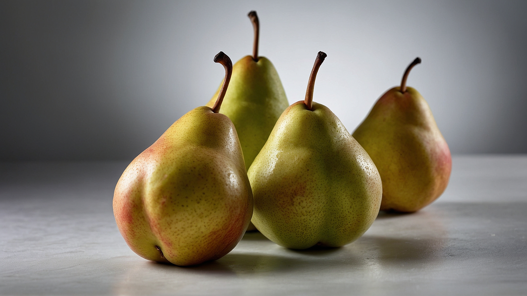 Four pears on a grey background with soft shadows, sharp focus, and professional color grading.