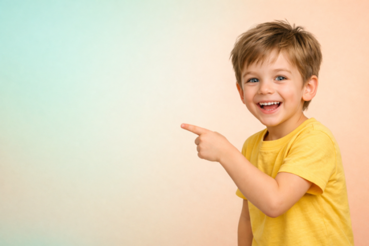 Smiling young boy in yellow shirt pointing right with a happy expression against a soft pastel background