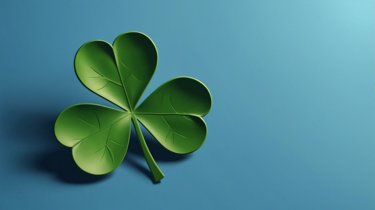 A vibrant green four-leaf clover with detailed veins casting a soft shadow on a smooth blue surface