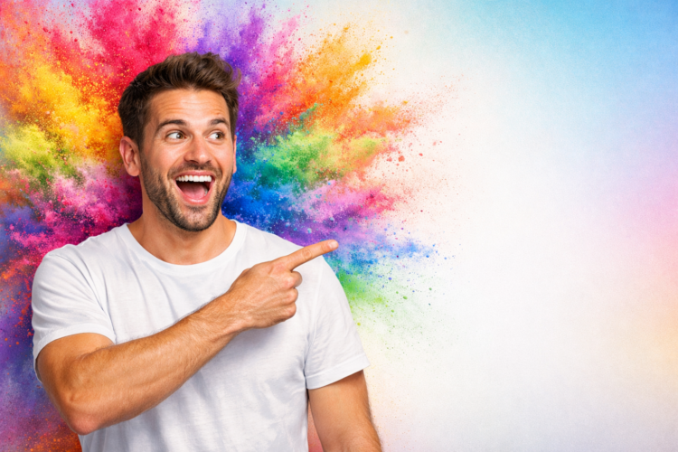 Excited young man in white shirt pointing joyfully with a burst of vibrant colored powder behind him
