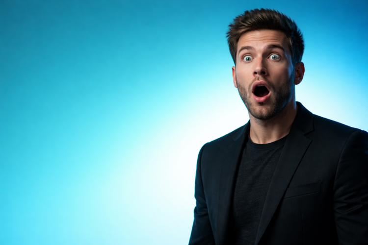 Portrait of a surprised young man with an open mouth and wide eyes against a smooth blue gradient background