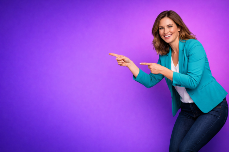 Happy woman in blue blazer and jeans smiling and pointing to the right side on a bright purple background
