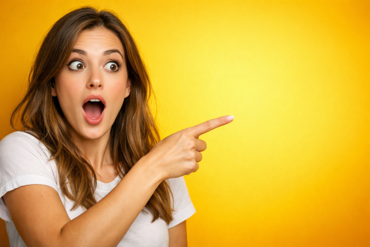 Young woman with an amazed expression pointing to the right on a vibrant yellow background