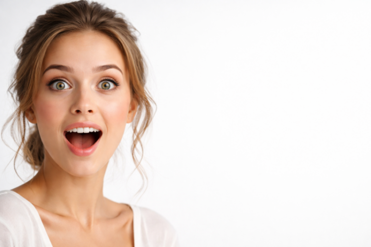 Close-up portrait of a surprised young woman with wide green eyes and open mouth on a white background